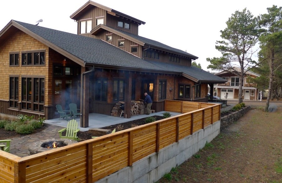 Réalisation d'une façade de maison marron design en bois de taille moyenne et à deux étages et plus avec un toit à deux pans.