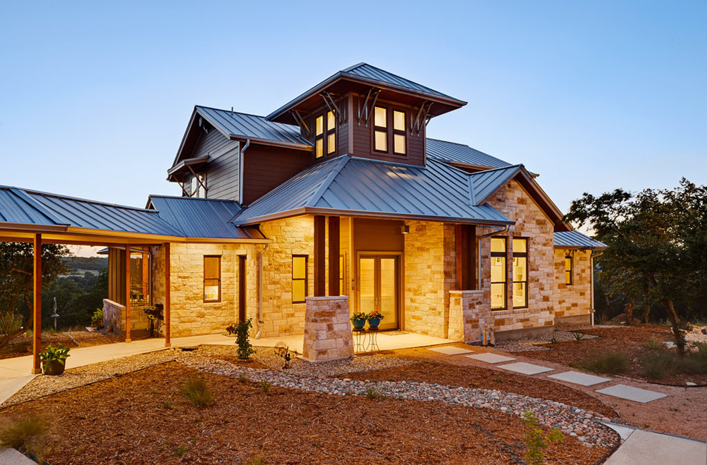 This is an example of a country two floor house exterior in Austin with stone cladding.