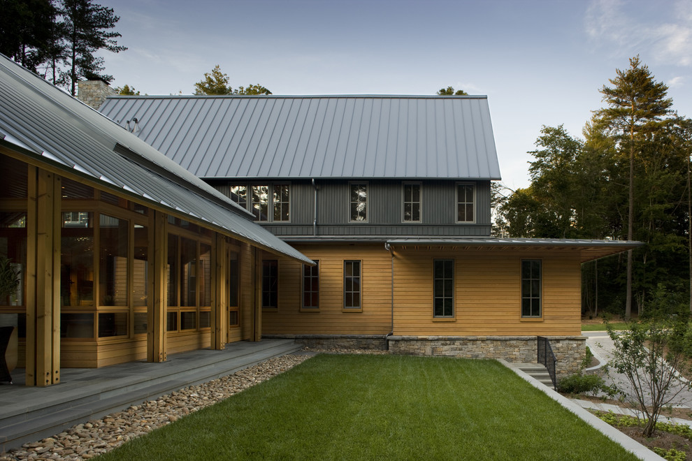 Стильный дизайн: деревянный, двухэтажный, коричневый частный загородный дом в стиле неоклассика (современная классика) с металлической крышей и отделкой планкеном - последний тренд