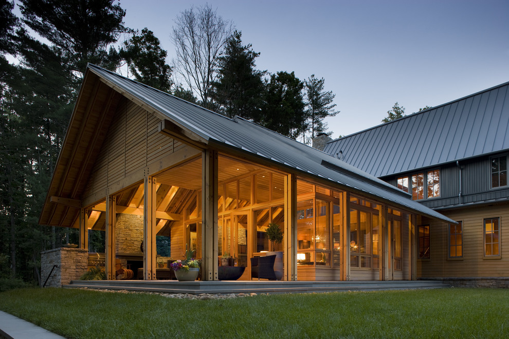 Imagen de fachada de casa marrón clásica renovada con revestimiento de madera y tejado de metal