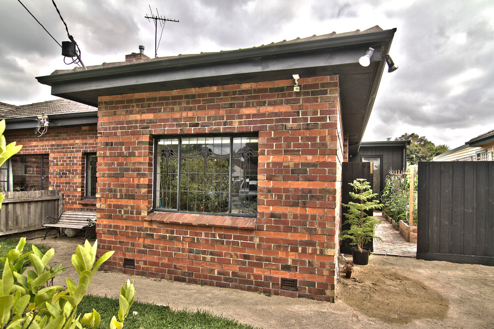 Mittelgroßes, Einstöckiges Industrial Haus mit Metallfassade, schwarzer Fassadenfarbe und Flachdach in Melbourne