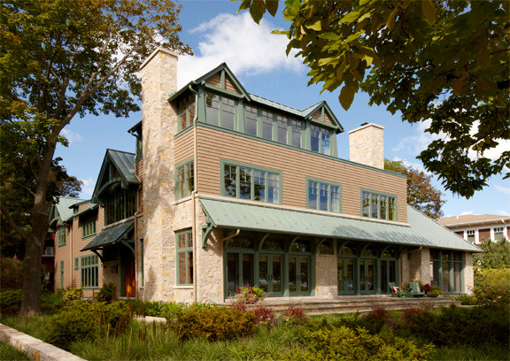 Foto de fachada beige de estilo americano grande de tres plantas con revestimiento de piedra y tejado a dos aguas