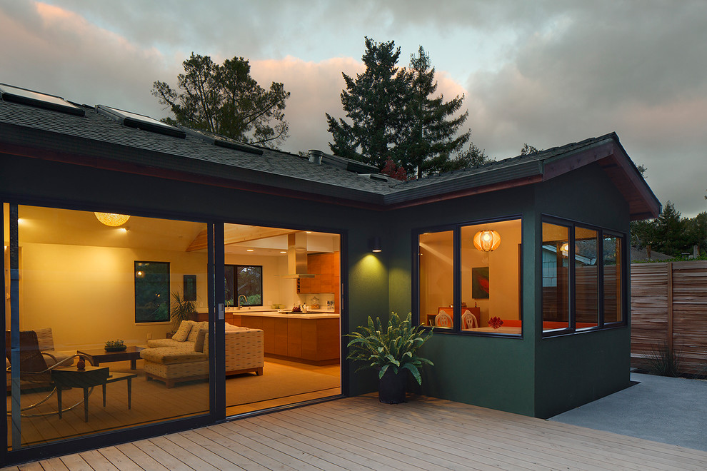 Exemple d'une façade de maison verte moderne en stuc de taille moyenne et de plain-pied avec un toit à deux pans.