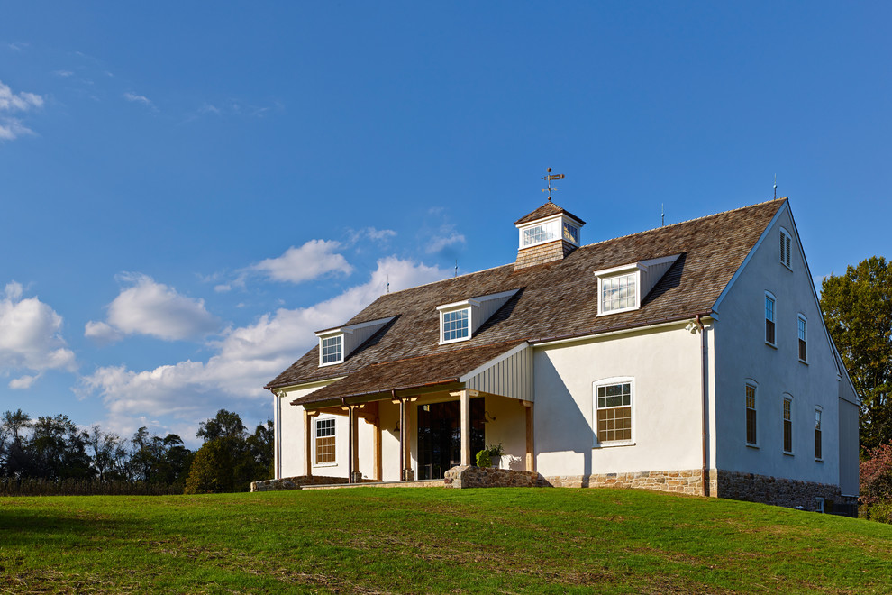 Foto della facciata di una casa country con rivestimenti misti e tetto a capanna