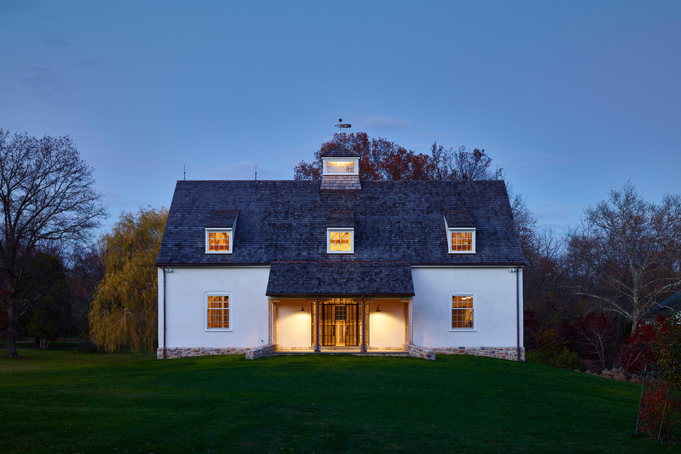 Réalisation d'une façade de grange rénovée blanche champêtre de plain-pied avec un toit à deux pans et un toit en shingle.