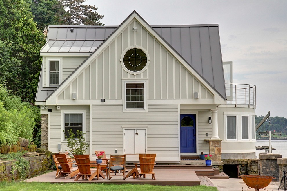 Пример оригинального дизайна: двухэтажный, деревянный, серый дом в морском стиле с двускатной крышей