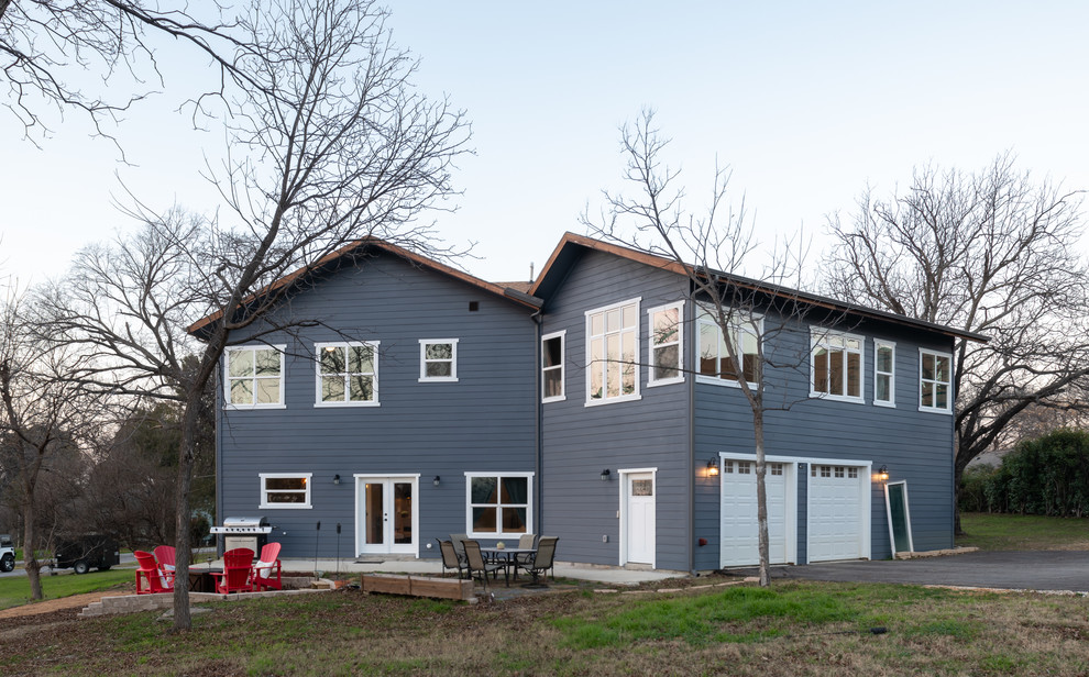 Réalisation d'une grande façade de maison bleue craftsman à un étage avec un revêtement en vinyle, un toit à deux pans et un toit en shingle.