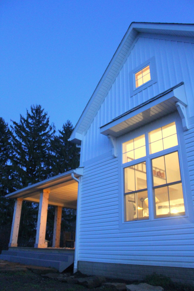 Inspiration pour une petite façade de maison blanche rustique à un étage avec un revêtement en vinyle et un toit à deux pans.