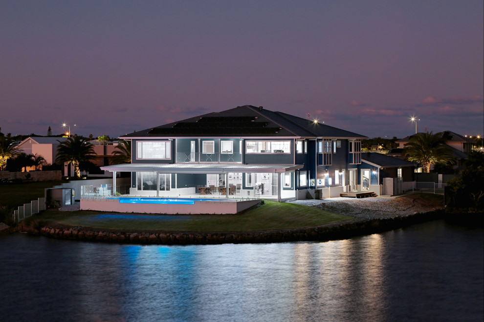 Идея дизайна: огромный, двухэтажный, синий частный загородный дом в морском стиле с облицовкой из ЦСП, вальмовой крышей и черепичной крышей