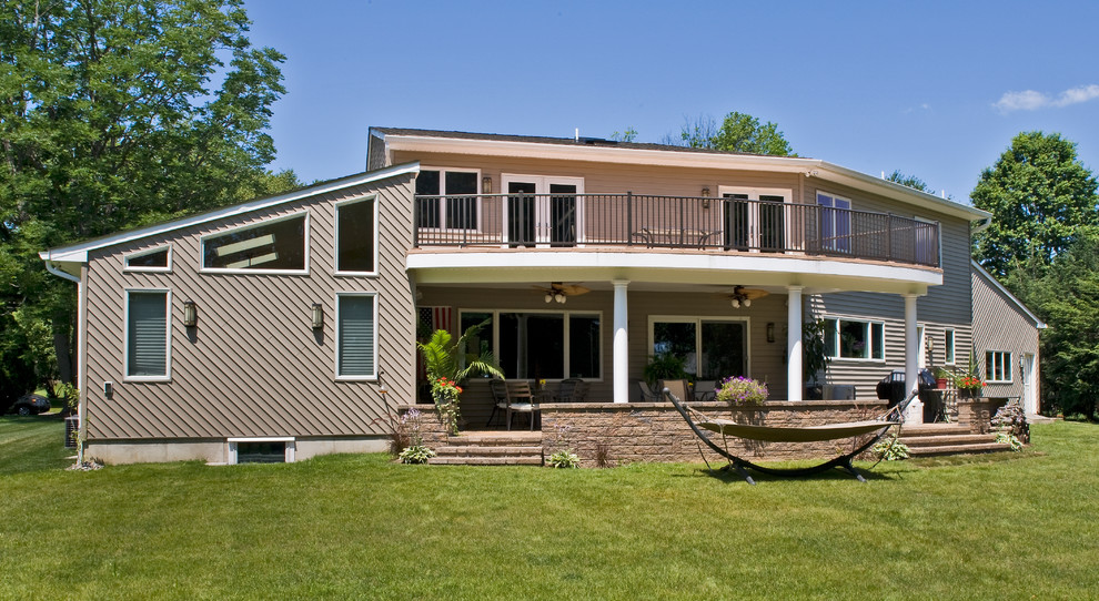 Foto della facciata di una casa ampia beige contemporanea a due piani con rivestimento in vinile