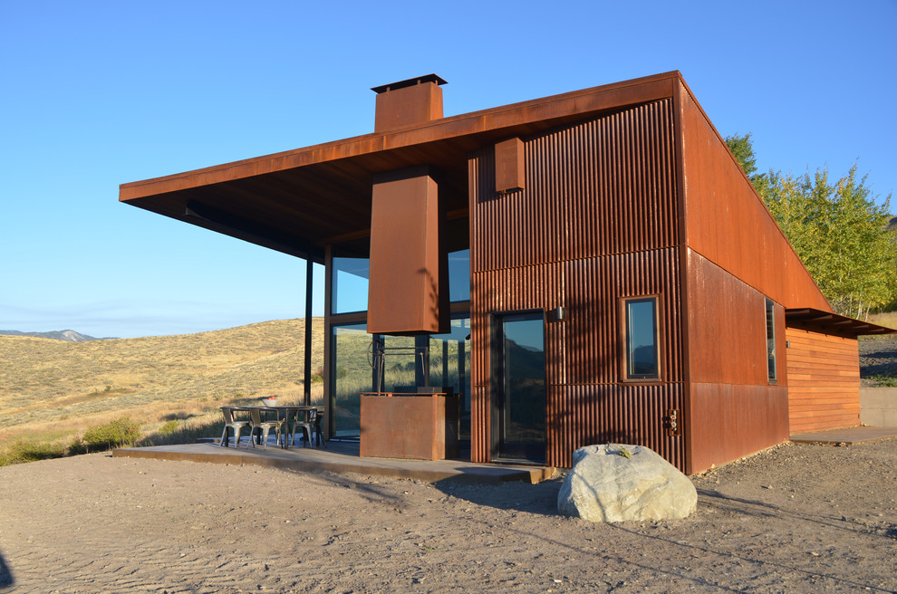 Cette photo montre une façade de maison marron moderne de taille moyenne et de plain-pied avec un revêtement mixte et un toit plat.