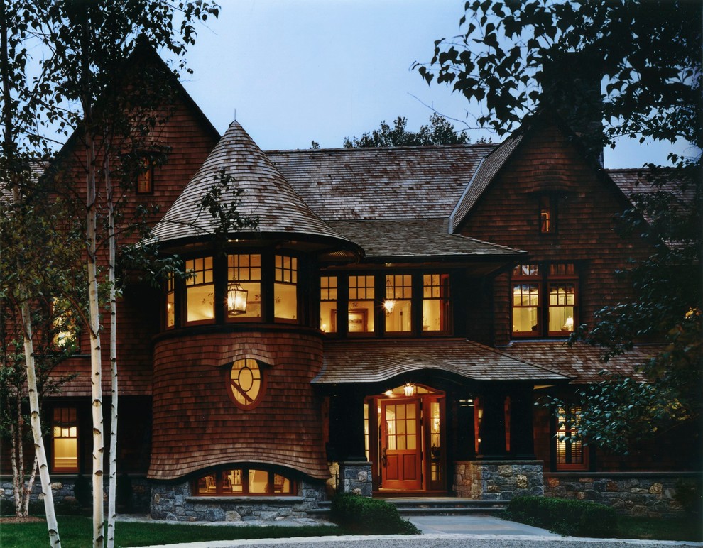 Réalisation d'une très grande façade de maison marron chalet en bois à un étage avec un toit à deux pans et un toit en shingle.