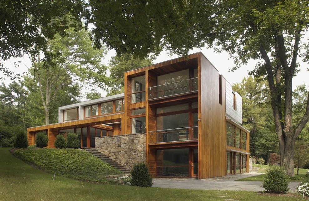 Diseño de fachada marrón moderna grande de tres plantas con revestimiento de madera y tejado plano