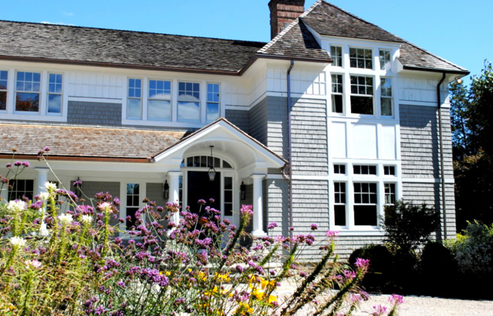 Exemple d'une grande façade de maison grise chic en bois à un étage avec un toit à quatre pans et un toit en shingle.