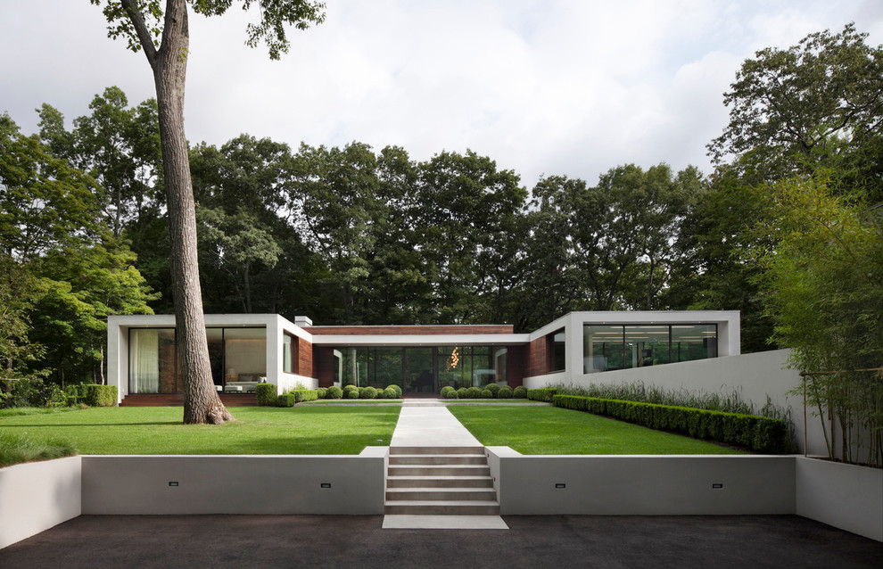 Diseño de fachada blanca moderna grande de una planta con revestimiento de estuco y tejado plano