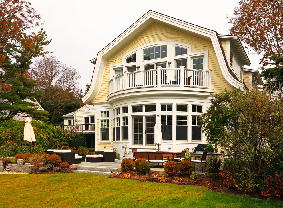 Photo of a large beach style two floor house exterior in Boston with wood cladding.