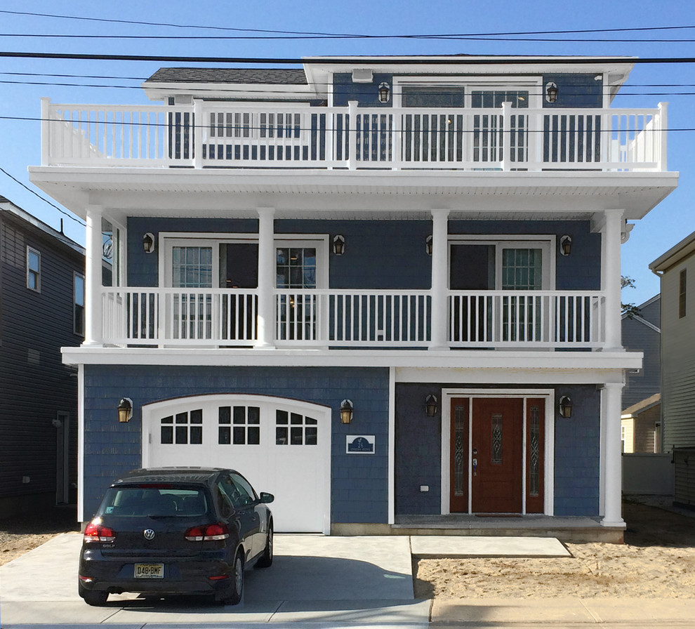 Immagine della facciata di una casa grande blu classica a tre piani con rivestimento in vinile