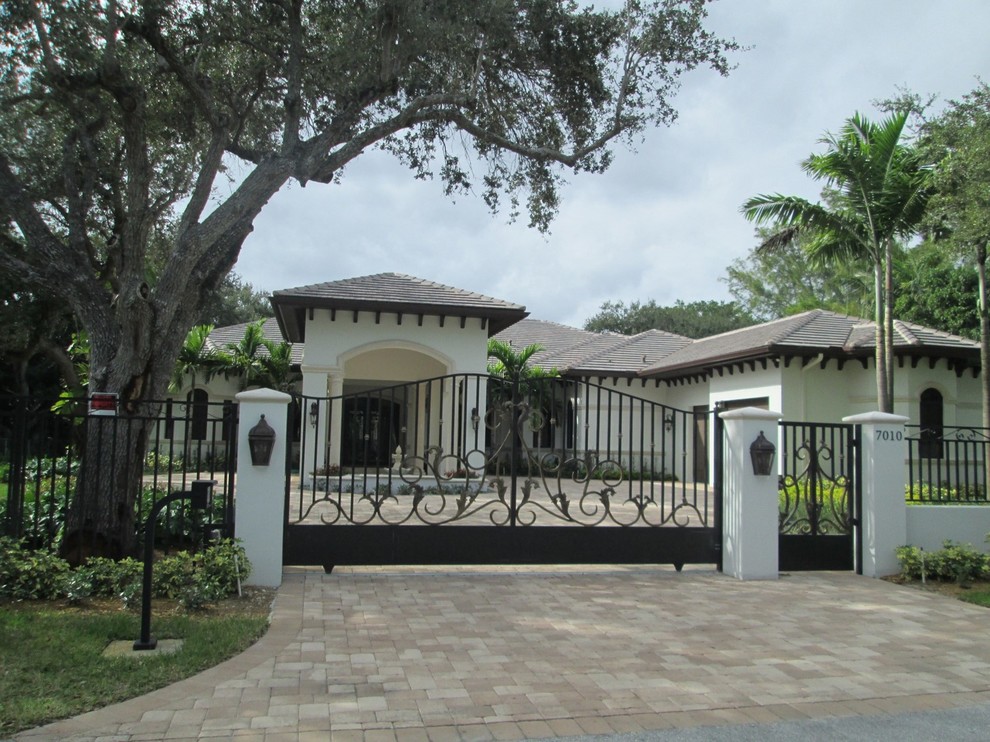 Großes, Einstöckiges Mediterranes Haus mit Steinfassade, weißer Fassadenfarbe und Walmdach in Miami