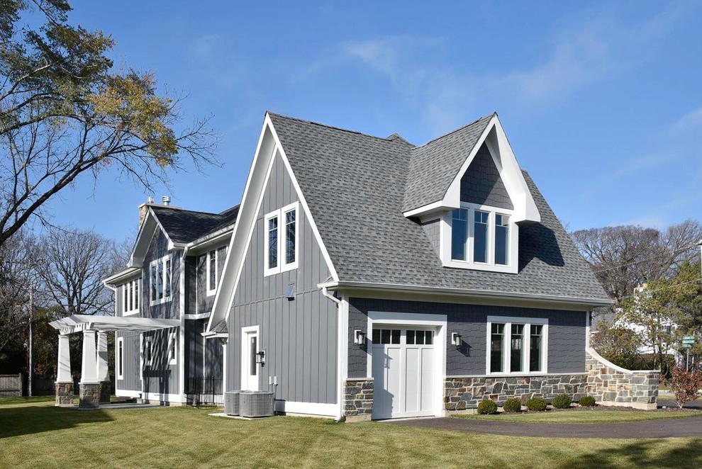 Modelo de fachada gris de estilo americano de tamaño medio de dos plantas con revestimientos combinados y tejado a dos aguas