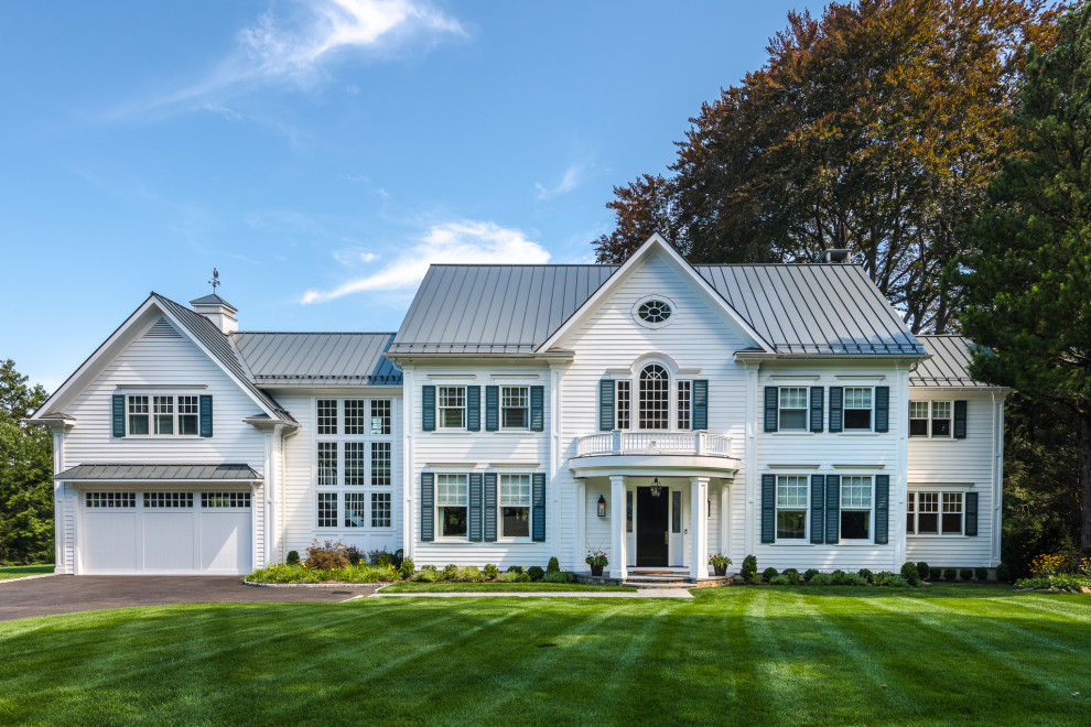 Inspiration for a timeless white two-story exterior home remodel in New York with a metal roof