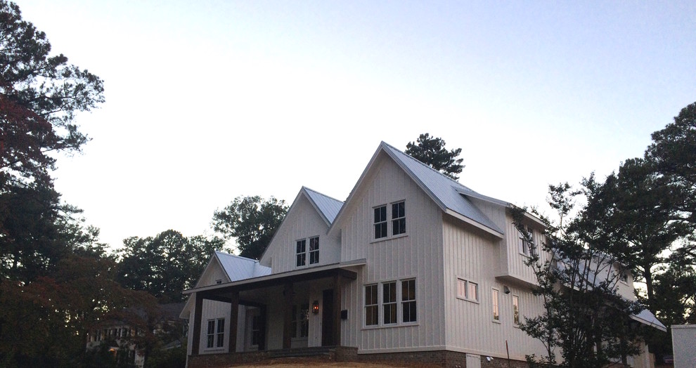 Cette image montre une façade de maison blanche rustique en panneau de béton fibré de taille moyenne et à un étage avec un toit à deux pans et un toit en métal.