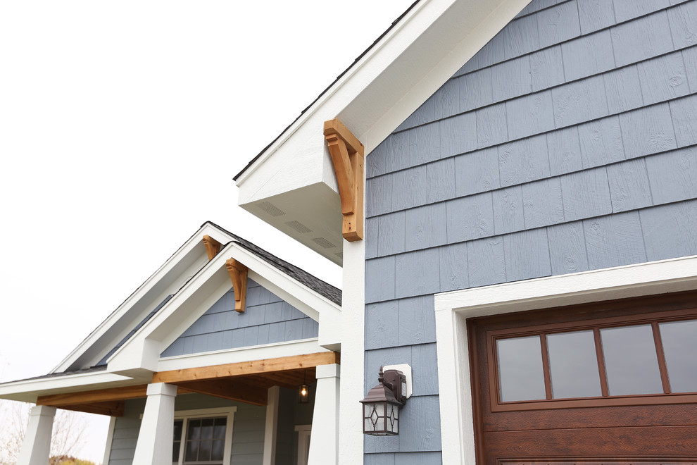 Inspiration for a large craftsman blue two-story wood house exterior remodel in Minneapolis with a hip roof and a shingle roof