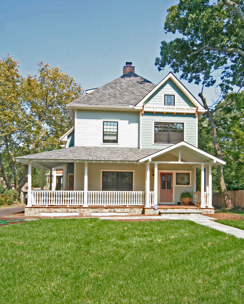Ejemplo de fachada de casa azul tradicional con revestimientos combinados y tejado de teja de madera