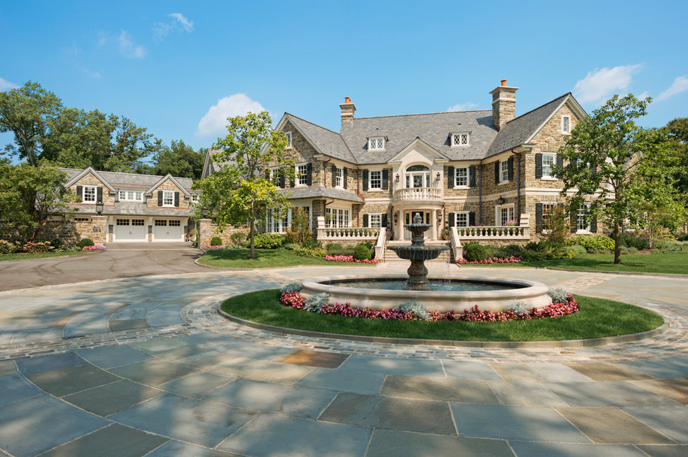 Large traditional beige three-story stone exterior home idea in Philadelphia with a shingle roof