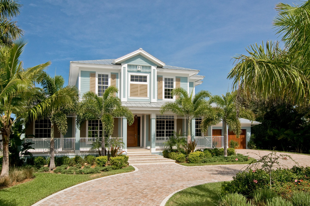 Immagine della villa blu tropicale a due piani di medie dimensioni con rivestimento in legno, tetto a padiglione e copertura in metallo o lamiera