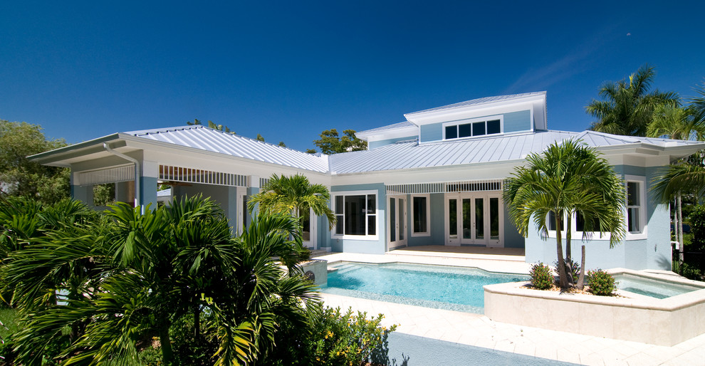Mittelgroßes, Zweistöckiges Maritimes Einfamilienhaus mit Putzfassade, blauer Fassadenfarbe, Walmdach und Blechdach in Miami