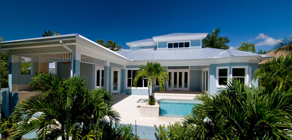 Mid-sized coastal blue two-story stucco house exterior idea in Miami with a metal roof