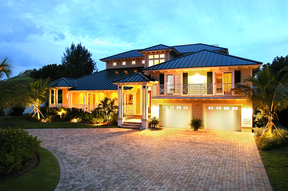 Aménagement d'une façade de maison bord de mer de taille moyenne et à un étage avec un revêtement mixte, un toit à quatre pans et un toit en métal.