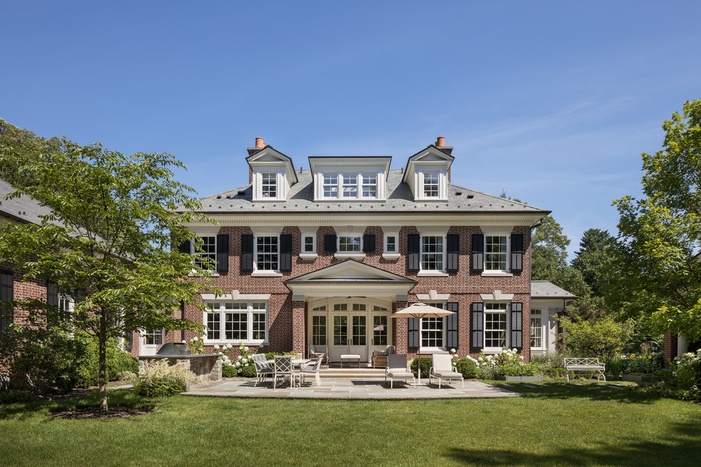 Elegant red two-story brick exterior home photo in New York with a shingle roof