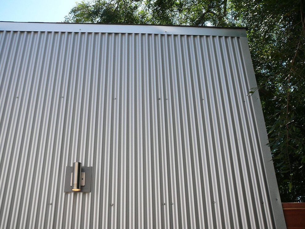 Foto de fachada gris industrial pequeña de una planta con revestimiento de metal y tejado a dos aguas