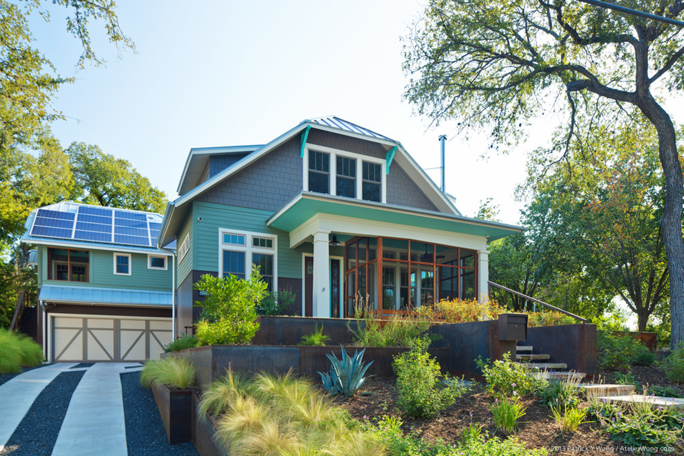 Cette photo montre une façade de maison verte craftsman en panneau de béton fibré à un étage avec un toit à croupette et un toit en métal.
