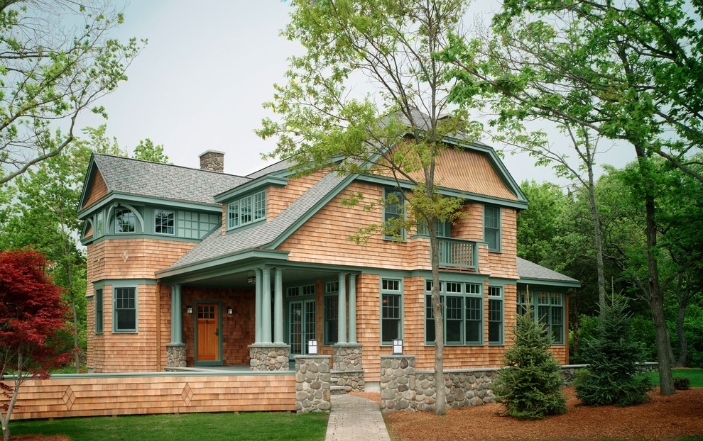 Foto della villa grande marrone american style a due piani con rivestimento in legno, falda a timpano e copertura a scandole