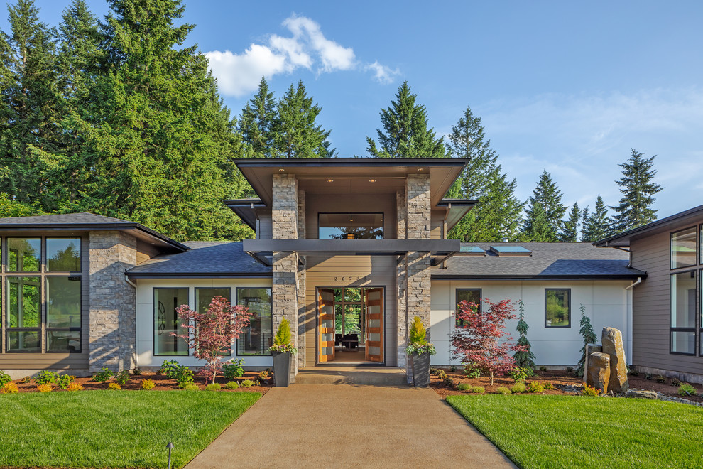 Imagen de fachada de casa multicolor actual con revestimientos combinados, tejado a cuatro aguas y tejado de teja de madera