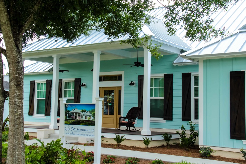 На фото: одноэтажный, синий частный загородный дом среднего размера в морском стиле с металлической крышей