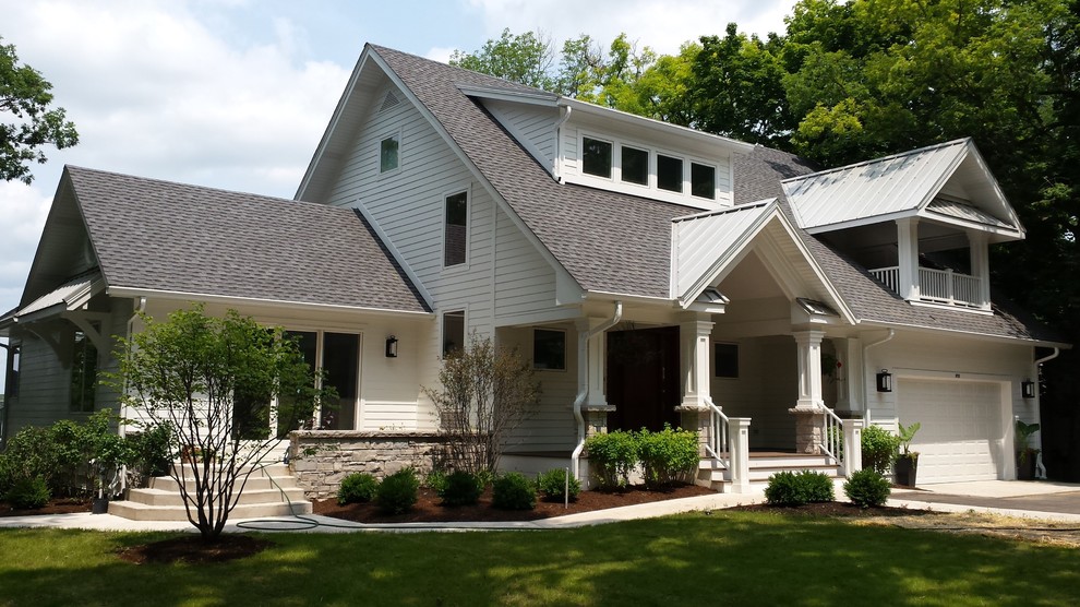 Modelo de fachada blanca clásica renovada de tamaño medio de tres plantas con revestimiento de aglomerado de cemento y tejado a dos aguas