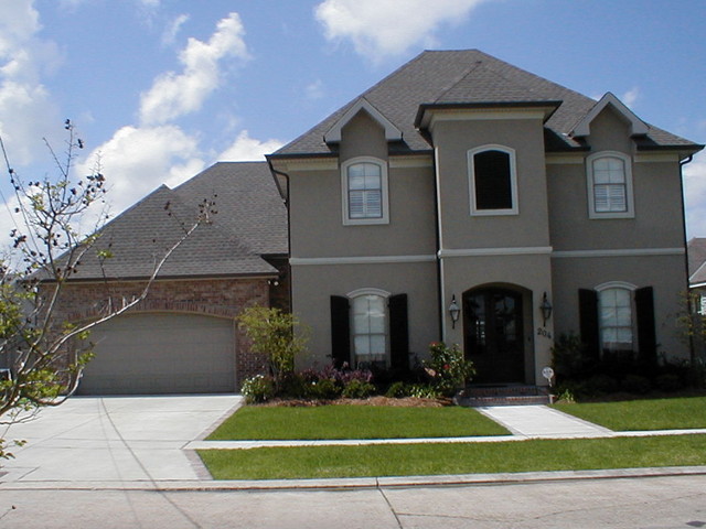 Cette photo montre une grande façade de maison marron chic à un étage avec un revêtement mixte, un toit à quatre pans et un toit en shingle.