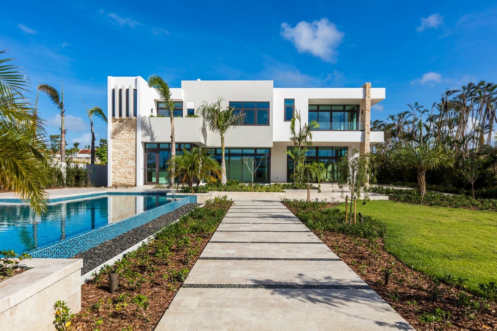 Großes, Zweistöckiges Modernes Einfamilienhaus mit Steinfassade, weißer Fassadenfarbe und Flachdach in Sonstige