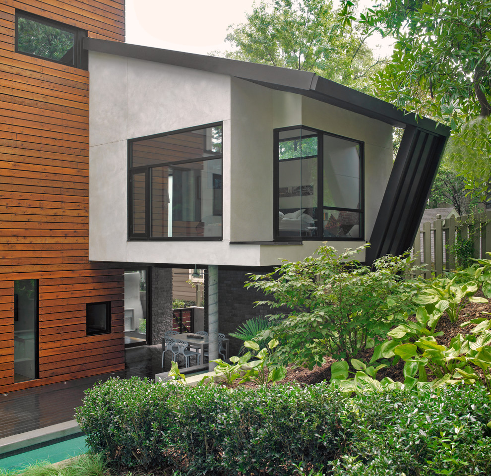 Exemple d'une grande façade de maison multicolore tendance en bois et bardage à clin à un étage avec un toit plat, un toit en métal et un toit noir.