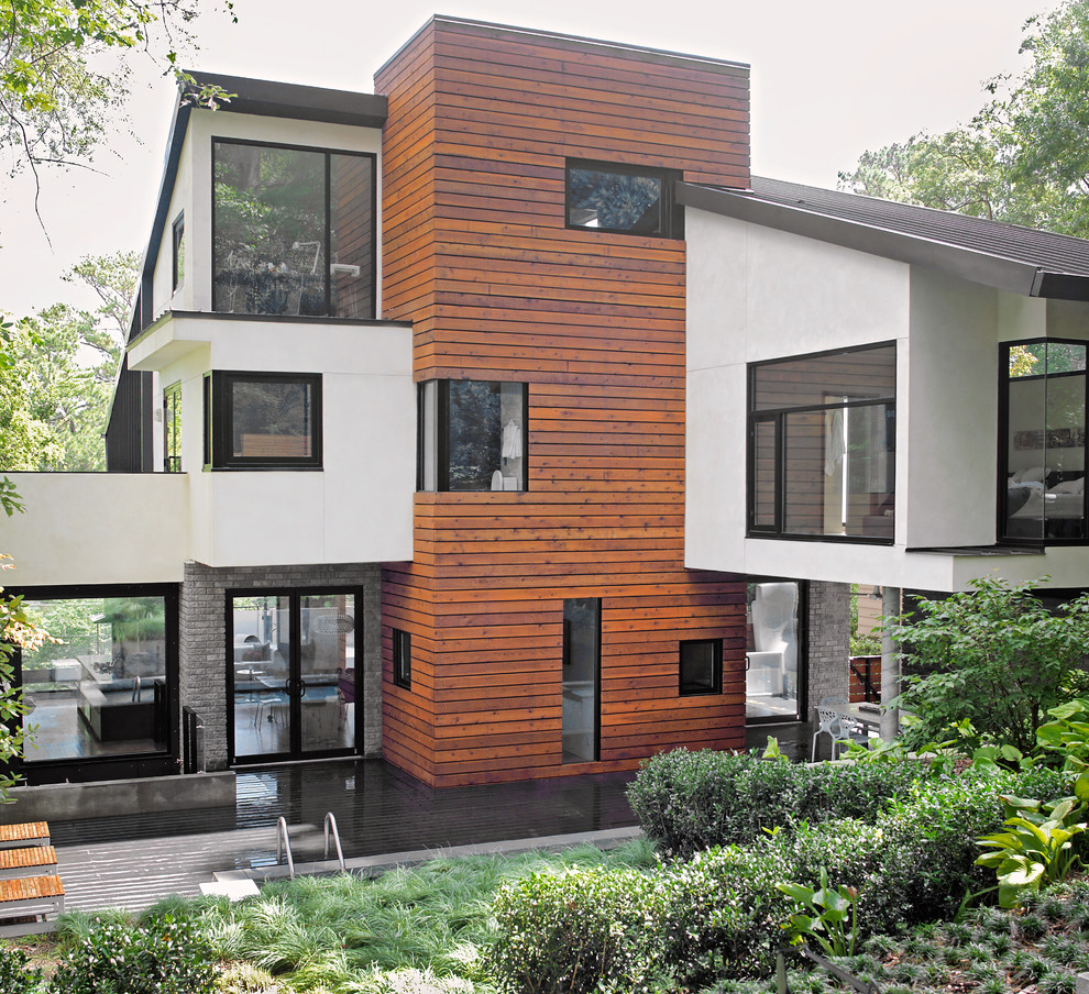Идея дизайна: деревянный, большой, двухэтажный, разноцветный частный загородный дом в современном стиле с плоской крышей, металлической крышей, черной крышей и отделкой планкеном