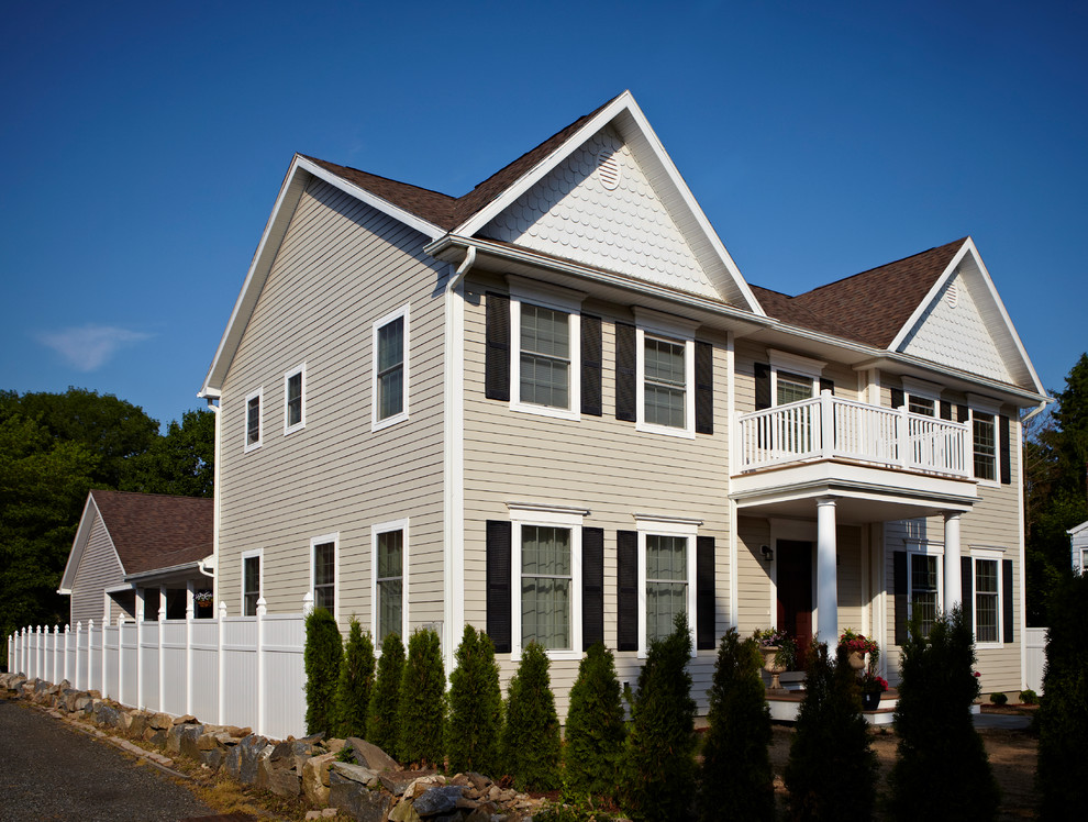 Cette image montre une façade de maison grise traditionnelle avec un revêtement en vinyle.