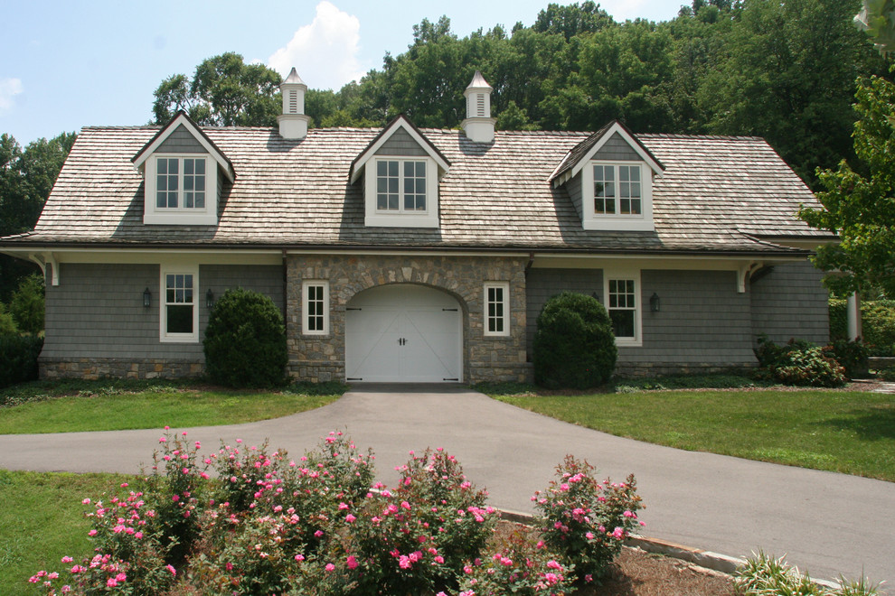 Cette image montre une très grande façade de maison grise rustique en bois à un étage avec un toit à deux pans.