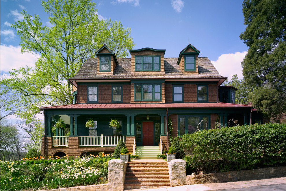 Immagine della facciata di una casa marrone american style a tre piani con rivestimento in legno e tetto a capanna