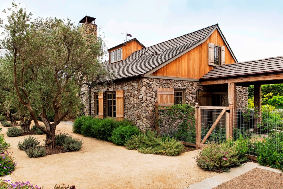 Example of a large farmhouse gray one-story stone exterior home design in Los Angeles with a shingle roof