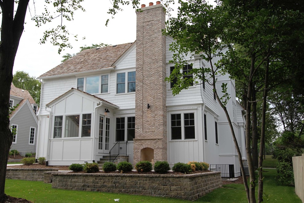 Inspiration for a large timeless white two-story wood gable roof remodel in Chicago