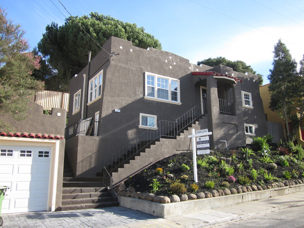 This is an example of a medium sized and gey mediterranean two floor render house exterior in San Francisco with a flat roof.