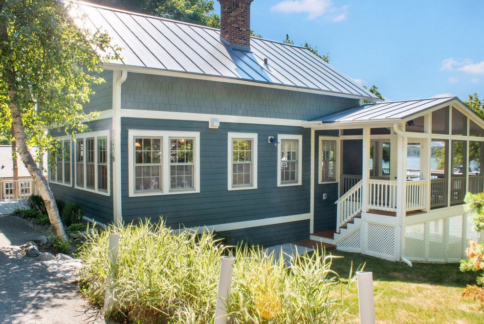 Large beach style blue two-story concrete fiberboard exterior home photo in Milwaukee with a metal roof